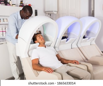 African American Man Hairdresser Washing Hair To Male Client In Modern Hair Salon