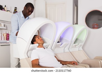 African American Man Hairdresser Washing Hair To Client In Modern Hair Salon