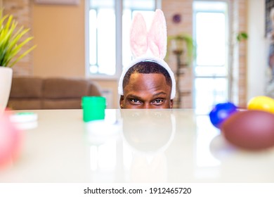 African American Man Hiding Under The Table On Easter In Apartment