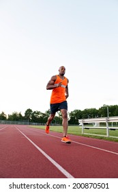 African American Man In His 30s Running At A Sports Track Outdoors.