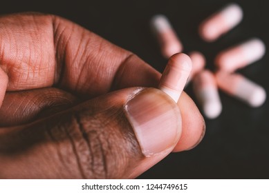 African American Man Holding Capsule Pill In Hand