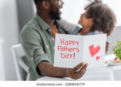 african american man holding greeting card with happy fathers day lettering near curly daughter on blurred background - Powered by Shutterstock