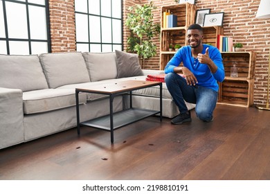 African American Man At Home With Cockroach Infestation Smiling Happy And Positive, Thumb Up Doing Excellent And Approval Sign 