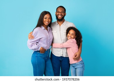 African American Man Hugging His Wife And Smiling Daughter