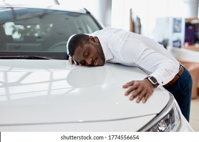 African American Man Hugs New Car He Dreams About, He Stand In Cars Showroom Next To White Automobile, Want To Buy It