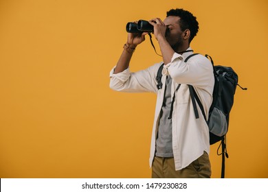 African American Man Looking Through Binoculars Isolated On Orange