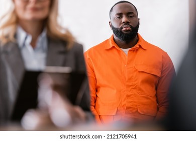 African American Man In Orange Jail Uniform Near Advocate On Blurred Foreground