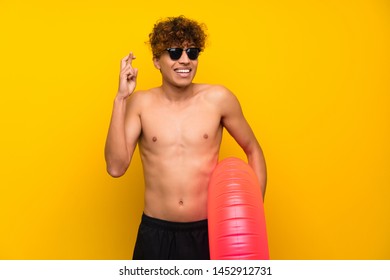 African American Man Over Isolated Purple Wall With Fingers Crossing