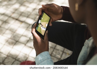 African american man in park watching cricket match on smartphone. sports, competition, entertainment and technology concept digital composite image. - Powered by Shutterstock