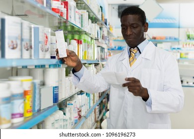 African American man pharmacist looking at prescription, searching prescribed drug on shelves in pharmacy
 - Powered by Shutterstock