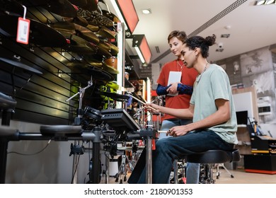 African American Man Playing Electronic Drums Near Seller With Digital Tablet In Music Store