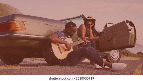 African american man playing guitar for his wife near the car on the street. Love, relationship and road trip concept - Powered by Shutterstock