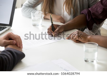 African american man puts signature on contract, interracial couple buying insurance or taking bank loan, making financial deal, family customers signing prenuptial agreement concept, close up view Stockfoto © 