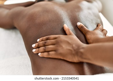 African american man reciving back massage at the clinic.