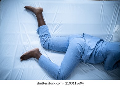 African American Man With RLS - Restless Legs Syndrome. Sleeping In Bed