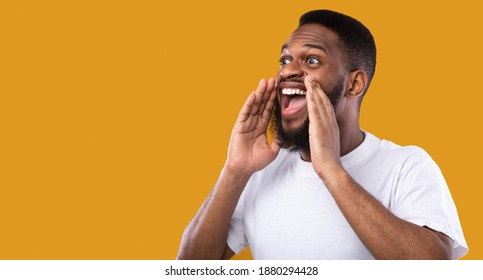 African American Man Shouting Holding Hands Near Mouth Drawing Attention To Advertisement Posing Standing Over Yellow Studio Background  Looking Aside  Great Offer Announcement  Panorama  Copy Space