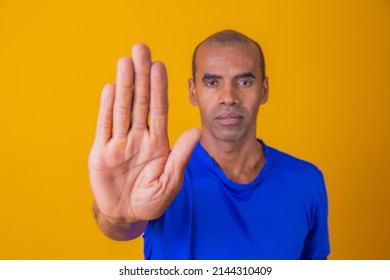 African American Man Shown Hand On Sign For Them To Stop With Racial Prejudice.