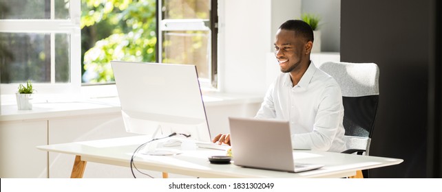 African American Man Sitting At Computer In Office