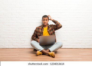 African american man sitting on the floor with his laptop with an expression of frustration and not understanding - Shutterstock ID 1234013614