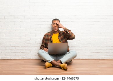 African american man sitting on the floor with his laptop has just realized something and has intending the solution - Shutterstock ID 1247468575
