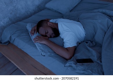 African American Man Sleeping, Resting In Bed In The Night At Home, Lying Near Smartphone. Always In Touch, Busy And Stressed Modern Life, Mobile Phone And Gadget Addiction Concept - Powered by Shutterstock