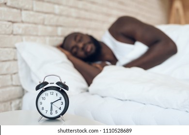 African American Man Sleeps In Bed Next To Alarm Clock. Healthy Sleep. Sweet Dreams.