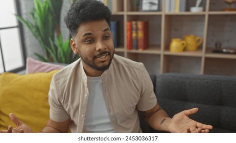 African american man smiling in modern living room with bookshelf - Powered by Shutterstock