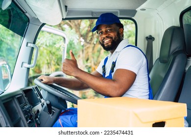 African American man smiling toward camera raise thumb up, confident delivery, moving house, shipping, courier man, professional service, sitting driving in truck. - Shutterstock ID 2235474431