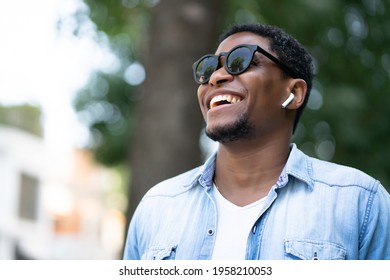 African american man smiling while walking outdoors. - Powered by Shutterstock