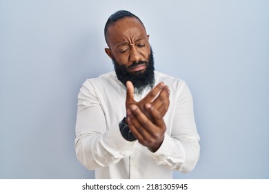 African American Man Standing Over Blue Background Suffering Pain On Hands And Fingers, Arthritis Inflammation 