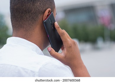 African American Man Talking On A Mobile Phone. Back View