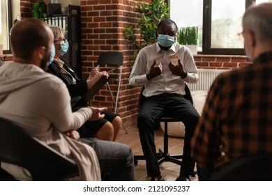 African American Man Talking To Psychiatrist At Aa Meeting With People Sitting In Circle At Group Therapy. Person With Face Mask Trying To Cure Addiction While Attending Support Session.