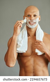 African American Man Using Brush While Applying Shaving Foam And Looking At Camera.