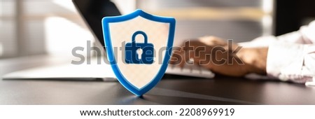 African American Man Using Secure Computer. Shield Sign