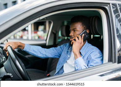 African American Man Using Smartphone Making Mobile Cell Call During Driving Time In Favourite Luxury Car.