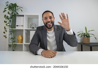 African American Man In Video Call Waves Hand Saying Hello To Coworker. Latino CEO Looking At Camera In Business Meeting