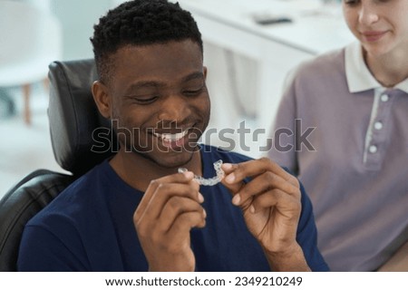 African American man wearing clear braces in order to get rid of malocclusion