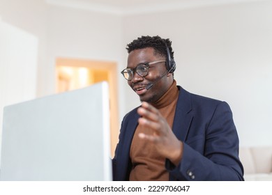 African American man wearing headphones reading good news in email, getting new job, promotion, using laptop - Shutterstock ID 2229706047