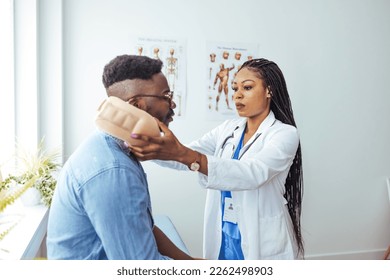 African American man wearing neck brace listening to doctor at hospital. Traumatologist talking to  male patient in cervical collar. Medical interview, professional help, injury treatment  - Powered by Shutterstock