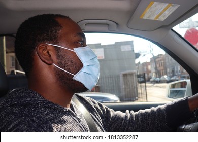 African American Man wearing surgical  face mask driving car  - Powered by Shutterstock