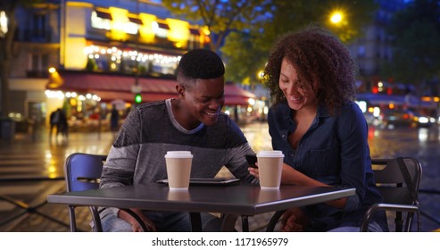 African American Man And Woman Drink Coffee And Use Smartphone On Paris Street