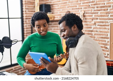 African American Man And Woman Music Group Using Touchpad Playing Ukelele At Music Studio