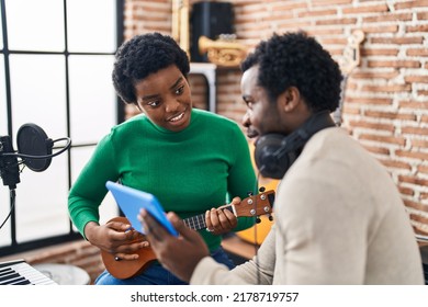 African American Man And Woman Music Group Using Touchpad Playing Ukelele At Music Studio