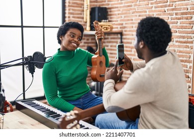 African American Man And Woman Music Group Make Photo Holding Ukelele At Music Studio