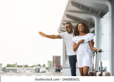 African american man and woman standing near road and trying to catch taxi, arriving at airport, free space - Powered by Shutterstock