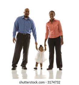 African American Man And Woman Standing Holding Up Infant Girl By Her Hands Against White Background.