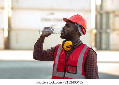 African American Man Worker Drinking Water And Resting After Working At Container Yard.