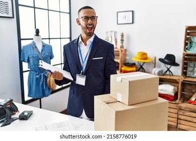 African american man working as manager at retail boutique angry and mad screaming frustrated and furious, shouting with anger. rage and aggressive concept. 