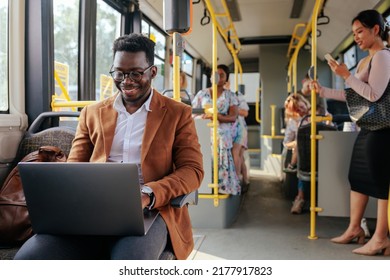 An african american man is working on his laptop while commuting to his work - Powered by Shutterstock