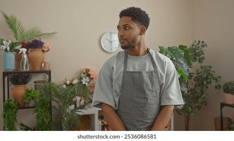 African american man working and posing thoughtfully in a lush indoor flower shop environment. - Powered by Shutterstock